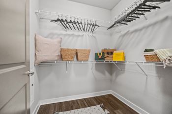 A white closet with a basket and a yellow box on the shelf at 1010 Dilworth Apartments, North Carolina